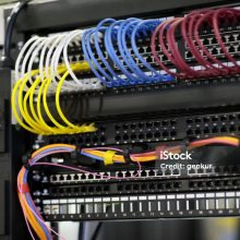 Network data rack with mounted networking equipment closeup. Patch cords and patch panels. Selective focus.